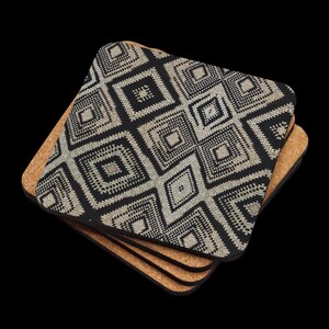 May include: A stack of square coasters with a black and beige geometric pattern. The coasters have a cork backing and a patterned top. The design features diamond shapes and a textured appearance. The coasters are stacked on a black background.