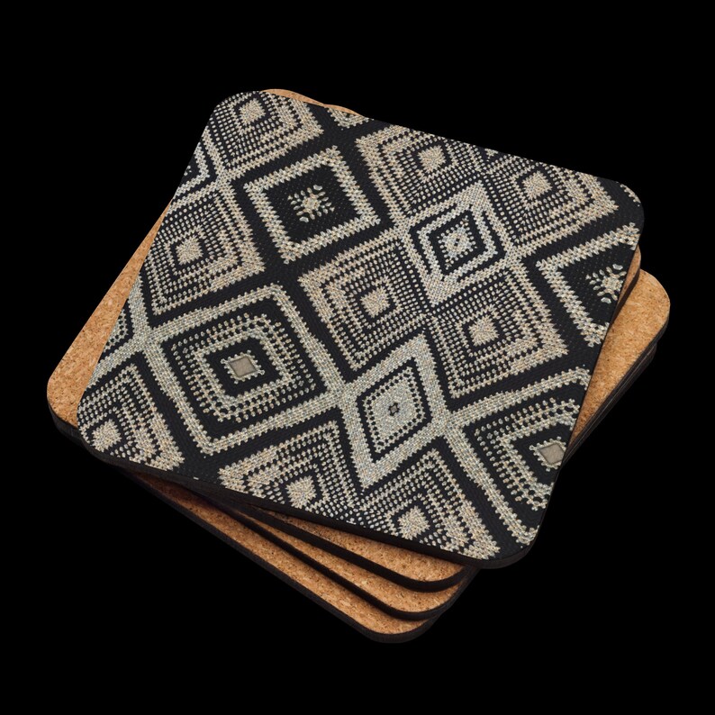May include: A stack of square coasters with a black and beige geometric pattern. The coasters have a cork backing and a patterned top. The design features diamond shapes and a textured appearance. The coasters are stacked on a black background.