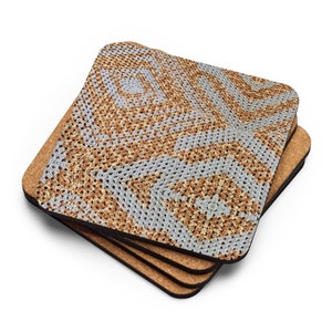 May include: A stack of four square coasters. The top coaster has a crocheted design in shades of light blue, tan, and brown. The coasters have a cork backing. The crocheted pattern is a repeating geometric design.