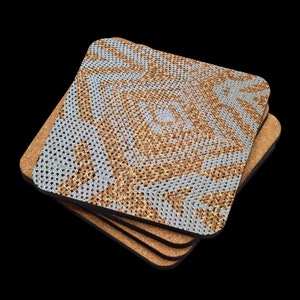 May include: A stack of four square coasters. Each coaster has a cork base and a top surface with a light blue and brown crocheted design. The design features a central square with radiating patterns.