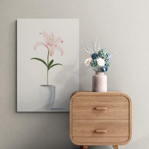 Pu&ograve; includere: Una stampa su tela raffigurante un giglio rosa in un vaso bianco. Il fiore ha petali delicati e foglie verdi. Un piccolo vaso con fiori blu e bianchi &egrave; posto su un comodino di legno.