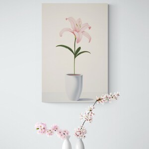 Pu&ograve; includere: Stampa su tela verticale con un giglio rosa in un vaso bianco. Il fiore ha petali delicati e foglie verdi. Il vaso ha un design semplice e moderno. Lo sfondo &egrave; di un colore morbido e neutro.