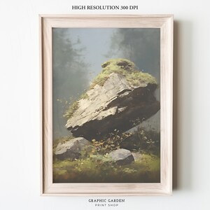 May include: A framed painting of a large, moss-covered rock in a forest setting. The rock is tilted at an angle, and there are smaller rocks and green foliage surrounding it. The background is a hazy, blue-grey color, suggesting a misty or foggy atmosphere.