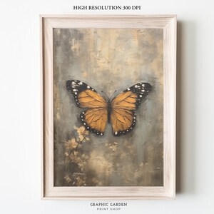 Puede incluir: Una impresi&oacute;n enmarcada de una pintura que presenta una gran mariposa naranja con marcas negras sobre un fondo texturizado gris y marr&oacute;n.