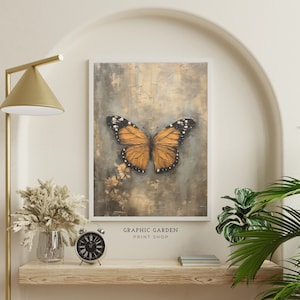Puede incluir: Una impresi&oacute;n enmarcada de una mariposa con alas naranjas y negras sobre un fondo texturizado. La impresi&oacute;n se titula "GRAPHIC GARDEN PRINT SHOP".