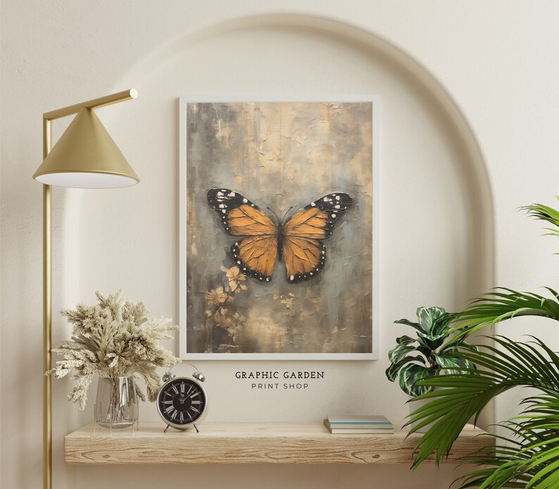 Puede incluir: Una impresi&oacute;n enmarcada de una mariposa con alas naranjas y negras sobre un fondo texturizado. La impresi&oacute;n se titula "GRAPHIC GARDEN PRINT SHOP".