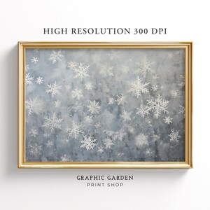 Puede incluir: Una impresión digital de una pintura de acuarela con un fondo azul y copos de nieve blancos de diferentes tamaños. La impresión está enmarcada en un marco dorado. El texto "GRAPHIC GARDEN PRINT SHOP" está en la parte inferior de la imagen.