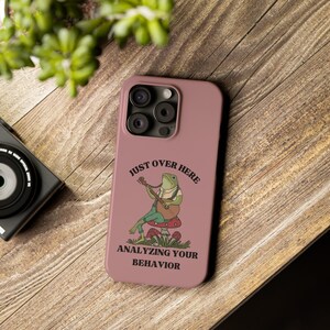 Könnte beinhalten: Eine rosa Handyhülle mit einem grünen Frosch, der Gitarre spielt, und dem Text "Just over here analyzing your behavior".