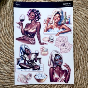 May include: A set of six stickers featuring illustrations of a Black woman in various self-care activities. The stickers are titled "me time stickers". The illustrations include a woman with rollers in her hair holding a glass of wine, a woman in a bathtub with bubbles, a woman in a bathrobe holding a glass of wine, a woman in a bathrobe sitting on a bed, a woman with a face mask on, and a pink bathrobe.