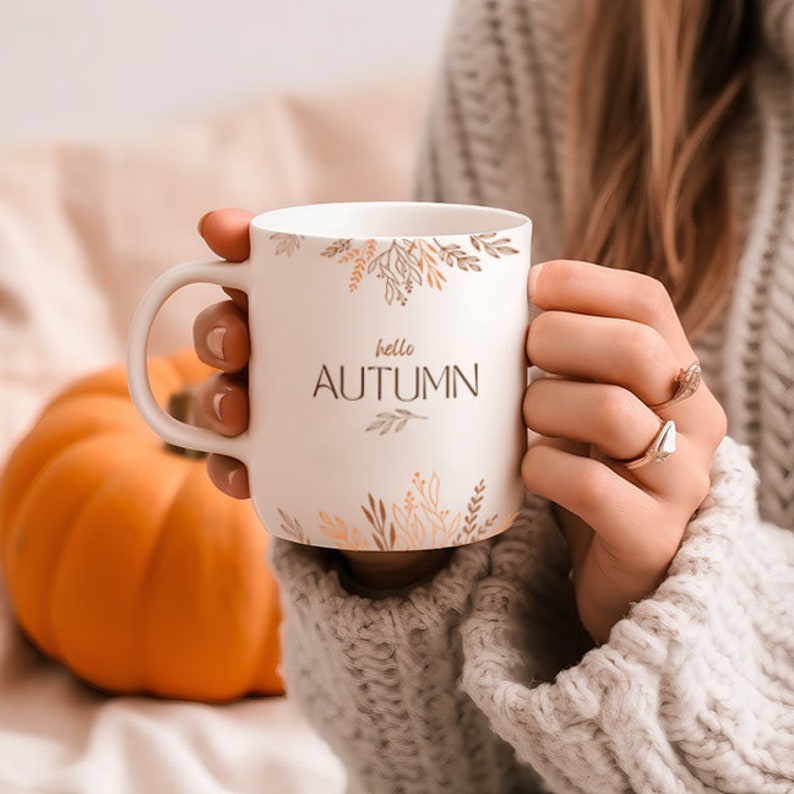 May include: White ceramic mug with a gold floral design and the text "hello autumn".