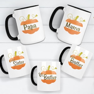 Pode incluir: Conjunto de seis canecas de cer&acirc;mica branca com al&ccedil;as pretas. Cada caneca apresenta um desenho de ab&oacute;bora com uma palavra diferente: Papai, Mam&atilde;e, Irm&atilde;zinha, Irm&atilde;o Mais Velho, Irm&atilde;o Mais Novo.