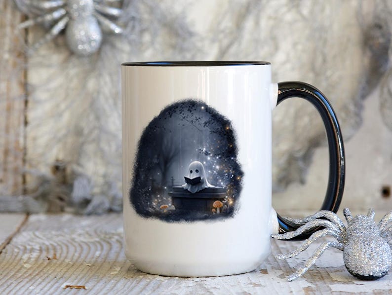 Puede incluir: Taza de cer&aacute;mica blanca con asa y borde negros. La taza presenta una ilustraci&oacute;n caprichosa de un fantasma leyendo un libro en un entorno de bosque oscuro. El dise&ntilde;o incluye setas y estrellas brillantes.