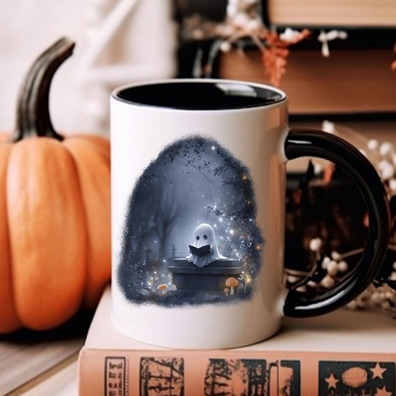 Puede incluir: Taza de cer&aacute;mica blanca con interior y asa negros. La taza presenta una ilustraci&oacute;n caprichosa de un fantasma leyendo un libro en un cementerio. Una calabaza es visible en el fondo, lo que sugiere un tema de Halloween.