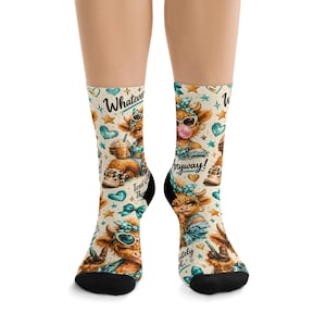 Puede incluir: Calcetines con un diseño caprichoso de vacas de dibujos animados. Los calcetines tienen un fondo crema con corazones y estrellas turquesas, y las frases "Whatever!" y "Anyway!". Las vacas llevan gafas de sol y pañuelos.