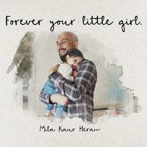 Op de afbeelding: Een vader en zijn dochter knuffelen. De vader draagt een geruit overhemd en de dochter draagt een wit overhemd. De tekst "Forever your little girl." staat boven hen. De tekst "Mila Kaur Heran" staat onder hen.