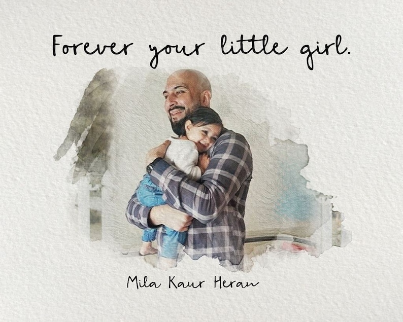 Op de afbeelding: Een vader en zijn dochter knuffelen. De vader draagt een geruit overhemd en de dochter draagt een wit overhemd. De tekst "Forever your little girl." staat boven hen. De tekst "Mila Kaur Heran" staat onder hen.