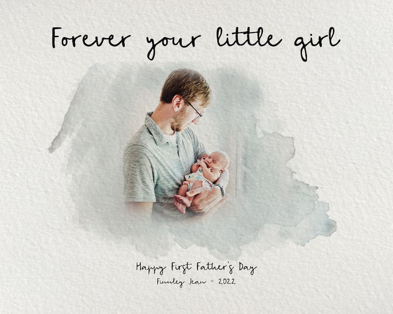 Op de afbeelding: Een vader houdt een pasgeboren baby in zijn armen. De afbeelding is omgeven door een aquareleffect. De tekst "Forever your little girl" staat bovenaan de afbeelding. De tekst "Happy First Father's Day" staat onderaan de afbeelding, samen met de tekst "Finley Jean - 2022."