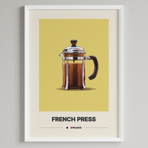 Könnte beinhalten: Eine Edelstahl-French-Press-Kaffeemaschine mit einer Glaskaraffe, gefüllt mit Kaffee. Die Kaffeemaschine befindet sich auf einem gelben Hintergrund mit dem Text "FRENCH PRESS" und "FRANCE" unterhalb des Bildes.
