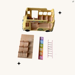 May include: A yellow toy bus with a ladder, slide, and seats. The bus has a colorful design with flowers and flags. The bus is part of a playset.
