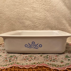 May include: White ceramic baking dish with a blue floral design. The dish has a rectangular shape and slightly rounded edges.