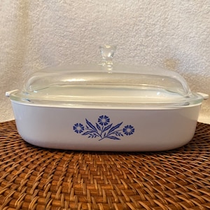 May include: White oval baking dish with a glass lid. The dish has a blue floral design with three flowers and leaves.