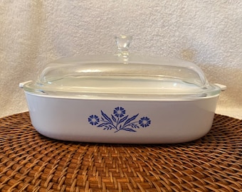 May include: White oval baking dish with a glass lid. The dish has a blue floral design with three flowers and leaves.