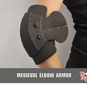 May include: A black foam elbow armour piece featuring a multi-layered design with two circular rivets on the upper section and white guide markings. The text MEDIEVAL ELBOW ARMOR and The Dodo Cosplay are printed on a grey banner at the bottom.