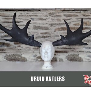 May include: A pair of black, foam, deer antlers on a white mannequin head. The antlers are marked with numbers. The text "DRUID ANTLERS" is at the bottom of the image. The text "The Dodo Cosplay" is in the bottom right corner.