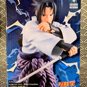 Pode incluir: Uma figura de Sasuke Uchiha da s&eacute;rie de anime Naruto, em caixa. A figura est&aacute; numa pose din&acirc;mica, segurando uma espada. A caixa apresenta o logotipo "Grandista" e o logotipo "Naruto", com um esquema de cores azul e branco.