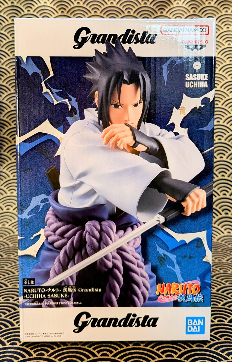 Pode incluir: Uma figura de Sasuke Uchiha da s&eacute;rie de anime Naruto, em caixa. A figura est&aacute; numa pose din&acirc;mica, segurando uma espada. A caixa apresenta o logotipo "Grandista" e o logotipo "Naruto", com um esquema de cores azul e branco.