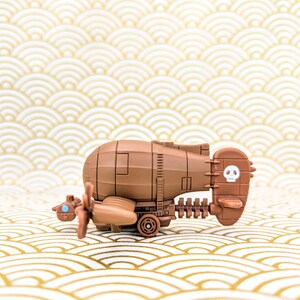 May include: A brown toy airplane with a skull and crossbones on the tail. The airplane has a propeller and wheels.