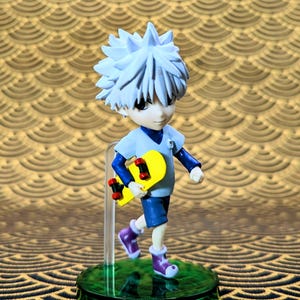 May include: A figurine of a character with spiky white hair, wearing a light blue shirt, dark blue shorts, and purple boots, holding a yellow skateboard with red wheels. The figure stands on a green base.