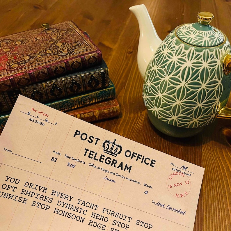 May include: A vintage Post Office Telegram form with a green and white patterned teapot and a stack of books in the background. The form has a space for the sender's name, address, and message. The form also has a space for the recipient's name and address. The form is dated November 16, 1932.