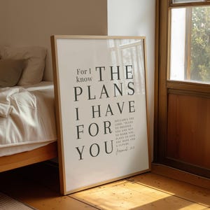 May include: A framed wall art print featuring black typography on a white background. The text reads: For I know THE PLANS I HAVE FOR YOU, followed by smaller text: DECLARES THE LORD, PLANS TO PROSPER YOU AND NOT TO HARM YOU, PLANS TO GIVE YOU HOPE AND A FUTURE. Jeremiah 29:11.