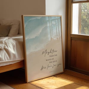 Può includere: Una stampa artistica da parete rettangolare incorniciata con un grafico di onde oceaniche blu chiaro e bianche che incontrano una spiaggia sabbiosa. Il testo recita: Mightier THAN THE WAVES OF THE SEA IS His love for you PSALM 93:4 in nero.