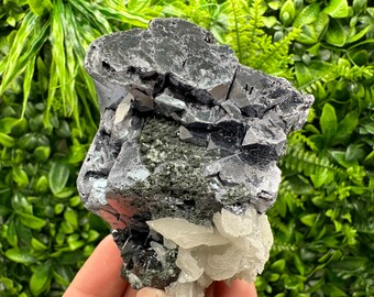 May include: A cluster of gray and silver galena crystals with a white calcite base. The crystals are sharp and have a metallic sheen.