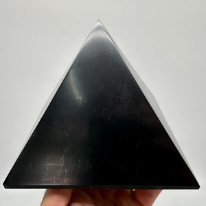May include: A black obsidian pyramid, a type of crystal used in healing and meditation.