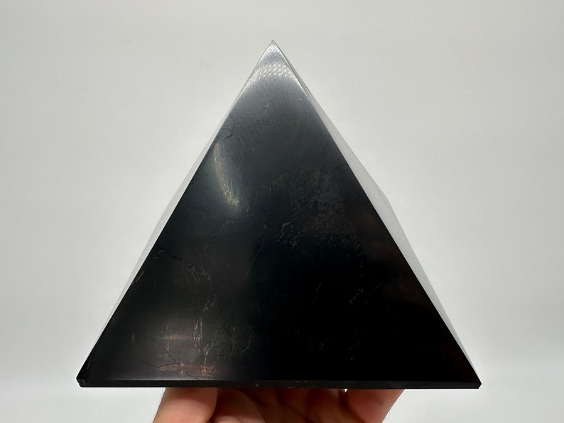 May include: A black obsidian pyramid, a type of crystal used in healing and meditation.