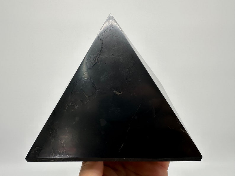 May include: A black obsidian pyramid, a type of crystal used in healing and meditation.