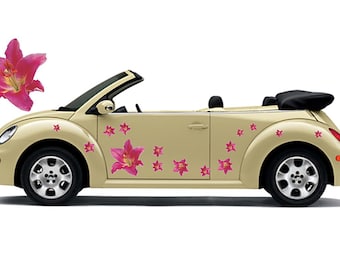 May include: A beige convertible car adorned with pink lily flower decals. The car features black tyres and a black convertible top. A large pink lily flower floats nearby.