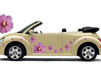May include: A beige convertible car adorned with pink hibiscus flower decals. The car features a black convertible roof and silver wheels. The flowers have water droplets on the petals.