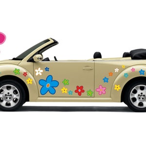 Puede incluir: Un coche descapotable beige decorado con calcomanías de flores de colores. El coche tiene una capota negra y ruedas negras. Un gran gráfico de flores rosas está en el lado izquierdo.