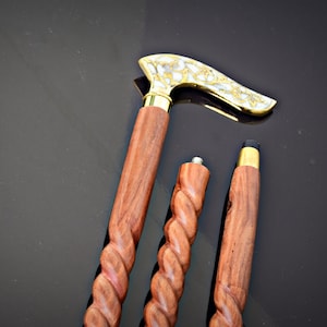 以下が含まれることがあります： ねじれたハンドルが付いた木製のステッキが3本。 上のステッキは、真鍮と白の装飾的なハンドルが付いています。