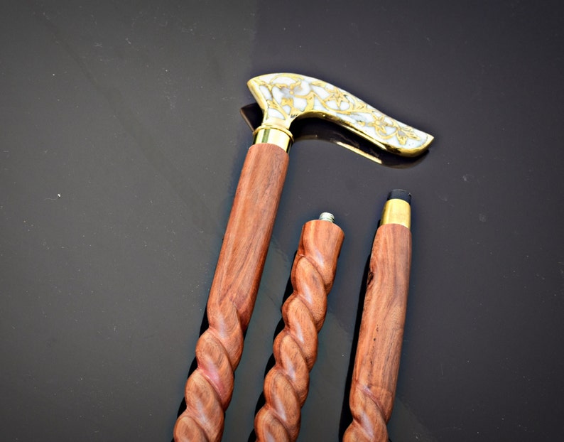 以下が含まれることがあります： ねじれたハンドルが付いた木製のステッキが3本。 上のステッキは、真鍮と白の装飾的なハンドルが付いています。