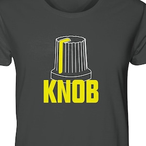 Könnte beinhalten: Ein dunkelgraues T-Shirt mit einer weißen Umrandung eines Knopfes und dem Wort "KNOB" in gelben Buchstaben.