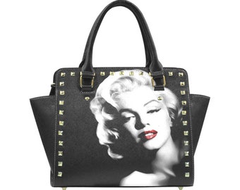 May include: Black handbag with gold studs and a black and white image of Marilyn Monroe on the front.