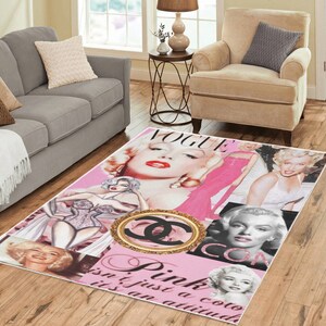 May include: Pink and white area rug with a collage of images of Marilyn Monroe, the Chanel logo, and the text "Pink isn't just a colour it's an attitude" and "Vogue" and "Icon".