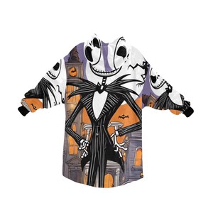 May include: A white hooded sweatshirt with a black and white print of Jack Skellington from The Nightmare Before Christmas. The print features Jack Skellington standing in front of a building with a purple sky in the background.