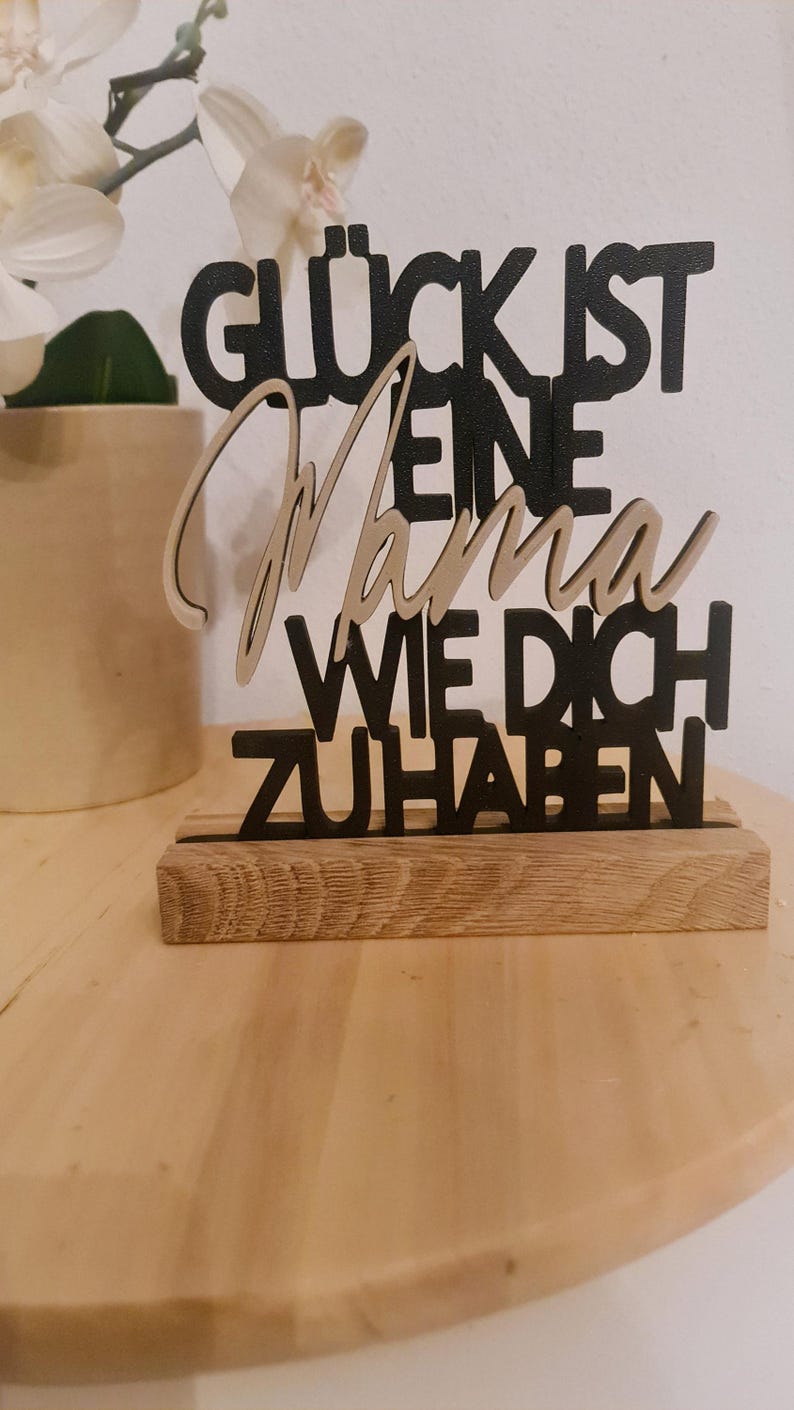 Pu&ograve; includere: Un cartello in legno nero con il testo "Gl&uuml;ck ist eine Mama wie dich zu haben" che si traduce in "La felicit&agrave; &egrave; avere una mamma come te".