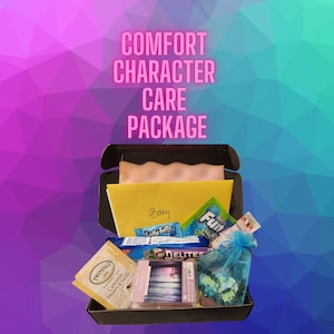 Könnte beinhalten: Eine schwarze Box gefüllt mit verschiedenen Artikeln, darunter Süßigkeiten, Tee und eine Karte mit dem Wort "Baby". Die Box enthält auch einen blauen Kordelzugbeutel und eine Packung "Mystic" Duftwachs-Schmelzstücke. Der Text "COMFORT CHARACTER CARE PACKAGE" wird über der Box angezeigt.